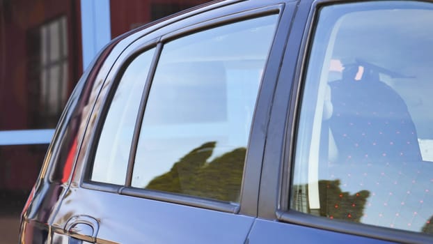 Clean car windows reflecting trees after car wash service