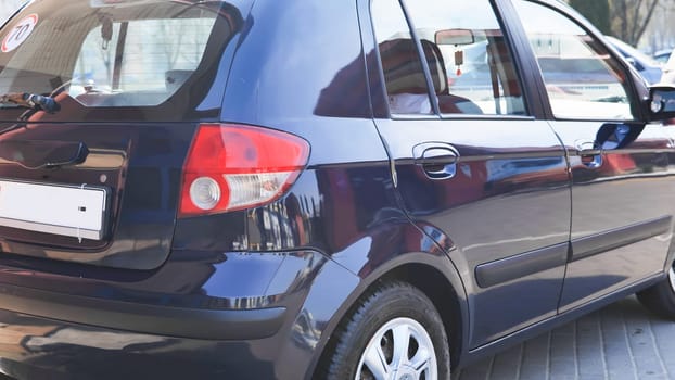 Clean and polished blue car reflecting urban landscape after car wash service