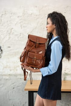 A fashionable model confidently showcasing a modern outfit while sporting a brown backpack accessory