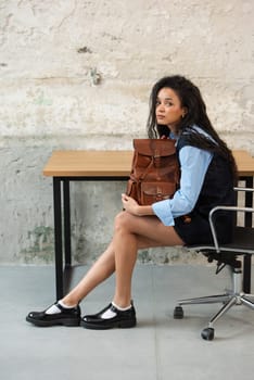 A fashionable model confidently showcasing a modern outfit while sporting a brown backpack accessory