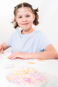 Little girl enjoys crafting colorful bracelets with vibrant clay beads set.