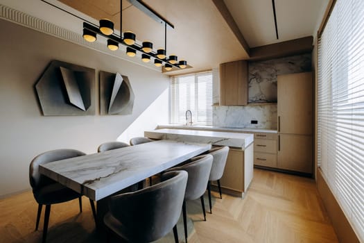 A beautifully arranged dining room featuring a stylish table along with comfortable chairs, and in the background, there is a lovely kitchen