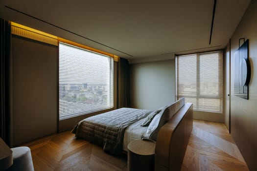 The bedroom is beautifully designed, featuring a spacious large bed, along with an expansive large window that allows for plenty of natural light
