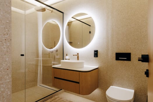 A wellequipped bathroom that features a toilet, a sink, a mirror for personal grooming, and a refreshing shower area