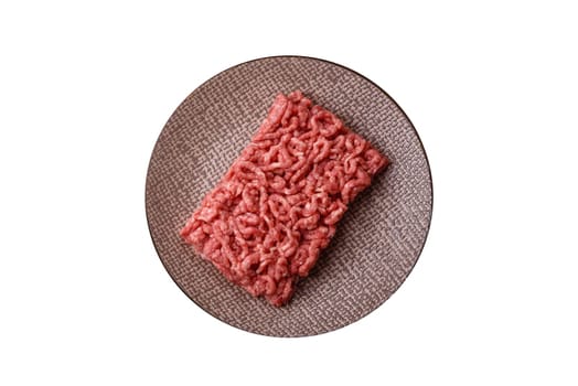 Stuffing or ground raw beef or pork with salt and spices on a black background