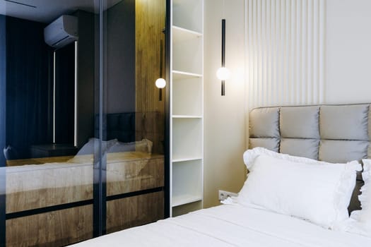 The bedroom features a spacious large bed complemented by a stylish mirror, creating an inviting atmosphere for relaxation