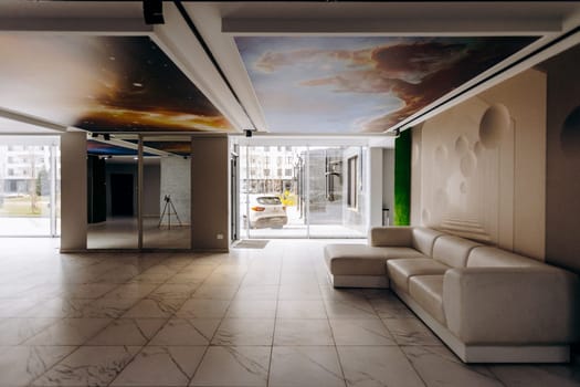 The interior of a living room features a comfortable couch along with an exquisite painting adorning the ceiling above it