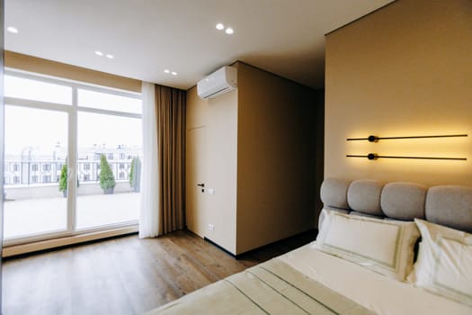 A cozy bedroom featuring a spacious large comfortable bed complemented by a large window that brings in plenty of natural light