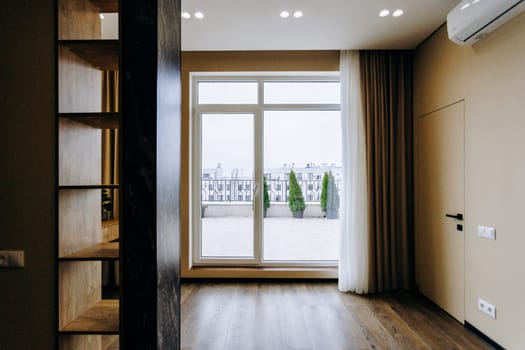 The room is empty, featuring a large window that offers a view and leads to a spacious balcony, enhancing its overall appeal and ambiance