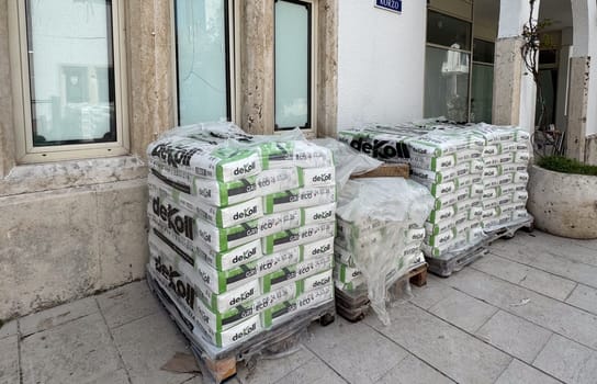 Budva, Montenegro - April 17, 2025: near VILA CORZO Stacked building materials at the construction site highlight the packaging of the deKoll brand