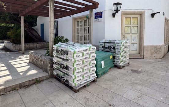 Budva, Montenegro - April 17, 2025: Stacked construction materials are located outside the VILA CANA building, indicating construction and renovation work