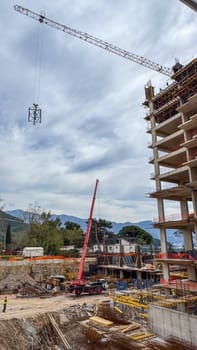Budva, Montenegro - April 18, 2025: Swissotel's construction site showcasing a crane lifting materials for a building construction project, highlighting industry growth and innovation
