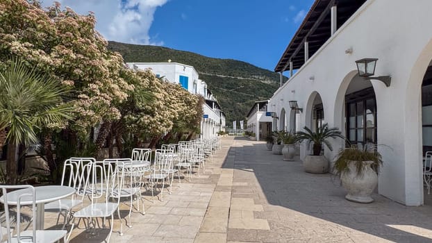 Budva, Montenegro - April 17, 2025: Surrounded by vibrant greenery and mountains, the open-air cafe Hotel Aleksandar offers a peaceful retreat