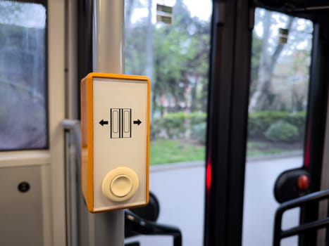 Detail of an automated door button inside a public transport vehicle, illustrating smart interface design and urban automation in everyday mobility systems. Push button in bus