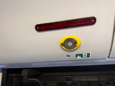 Close up of emergency mechanism with an icon based instruction system inside public transportation, highlighting functional and visual interface design