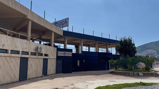 Budva, Montenegro - April 18, 2025: The exterior of La Bocca Restaurant with open upper levels and a paved walkway at the entrance under clear skies.