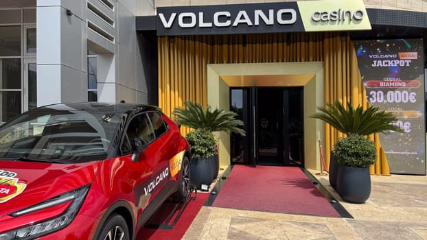 Budva, Montenegro - April 18, 2025: Entrance to the Vulkan Casino with a luxury car parked next to it, highlighting the thrill and entertainment of the gameplay
