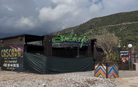 Budva, Montenegro - April 18, 2025: Located in Budva, the Cascada restaurant and bar with a bright sign and a closed net before the opening of the season