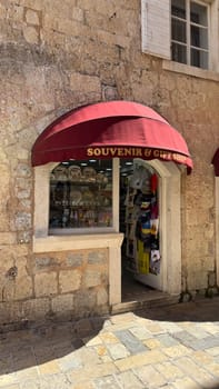Budva, Montenegro - April 18, 2025: Entrance to a charming souvenir shop located in the historic stone building of the Old Town, offering souvenirs for tourists and visitors
