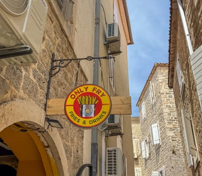 Budva, Montenegro - April 18, 2025: Only Fry restaurant sign on the wall of a house in the old town. highlights the appeal of delicious fries in a street atmosphere