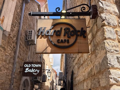 Budva, Montenegro - April 18, 2025: Hard Rock Cafe sign on the wall in the Old Town. Hard Rock Cafe is an international restaurant chain founded in 1971, known for its unique atmosphere