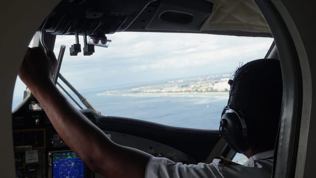 Pilot is skillfully maneuvering an aircraft over a tropical island, preparing for a smooth landing approach, showcasing the beauty of the destination from the cockpit's perspective