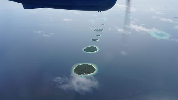 Capturing a breathtaking aerial view of maldives islands from a seaplane, revealing the stunning beauty of the tropical paradise with its turquoise waters, coral reefs, and serene landscapes