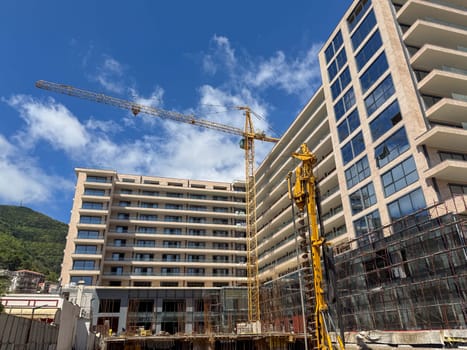Budva, Montenegro - April 18, 2025: Urban hotel construction site with cranes and modern architectural development, reflecting progress and innovation in urban landscapes