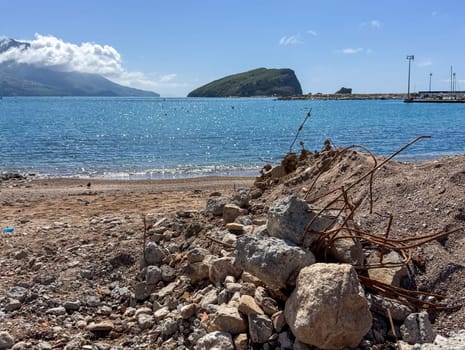 Budva, Montenegro - April 18, 2025: A coastal landscape showcasing renovation and restoration, with debris in the foreground and serene views of the water, highlighting the beauty of nature and renewal