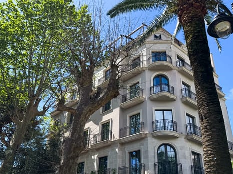 Budva, Montenegro - April 18, 2025: Budva, Montenegro - April 18, 2025: The historic building of the Majestic Hotel stands among lush trees with elegant architecture.