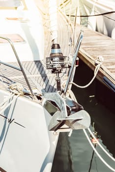 Sailboat anchor detail on sunny marina dock, background