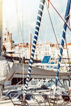 Sailboats anchored in vibrant marina on sunny day, featuring nautical details
