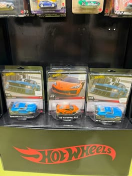 Tbilisi, Georgia, April 10, 2025: Collectible Hot Wheels cars in 1:43 scale displayed in retail packaging on store shelf, official licensed toys for children and collectors in brightly colored boxes
