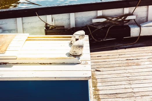 Boat deck with nautical ropes and wooden planks in sunlight background