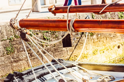 Boat ropes and wooden masts in a docked sailboat, harbor scene