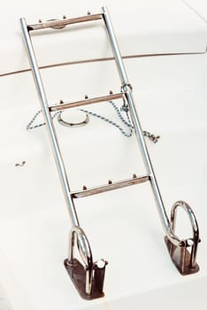 Boat ladder on white deck with rope, maritime equipment background