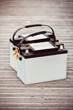 Car batteries sitting on wooden floorboards, industrial concept