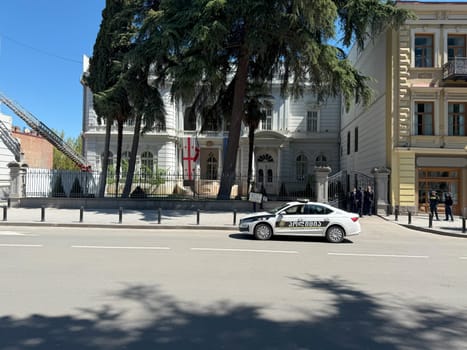 Tbilisi, Georgia, April 11, 2025: Lone man protests with sign in front of government building, while police stands nearby, guarding and overseeing the demonstration of just one individual