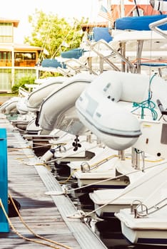 Boats docked at marina with white inflatables on sunny day