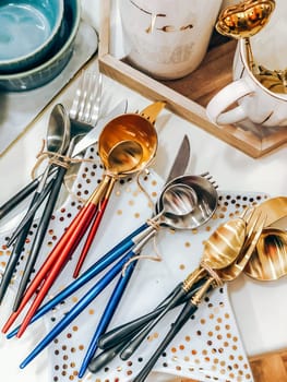 Colorful cutlery sets with wooden handles on white polka dot plates