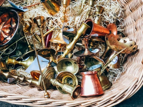 Antique brass and copper musical instruments in wicker basket, detailed texture