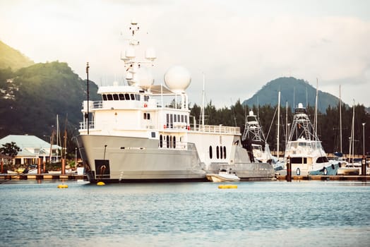 Yacht docked in marina with scenic mountain landscape in background