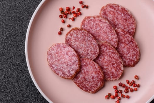 Sliced salami sausage, smoked meat, delicious deli snacks on a plate