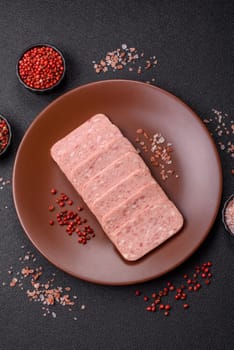 Canned ham, meat, pork, with spices and salt, slices on a dark concrete background