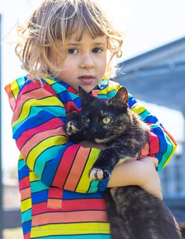 Child hugging a cat on the street. Selective focus. kid.
