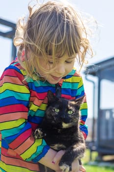 Child hugging a cat on the street. Selective focus. kid.