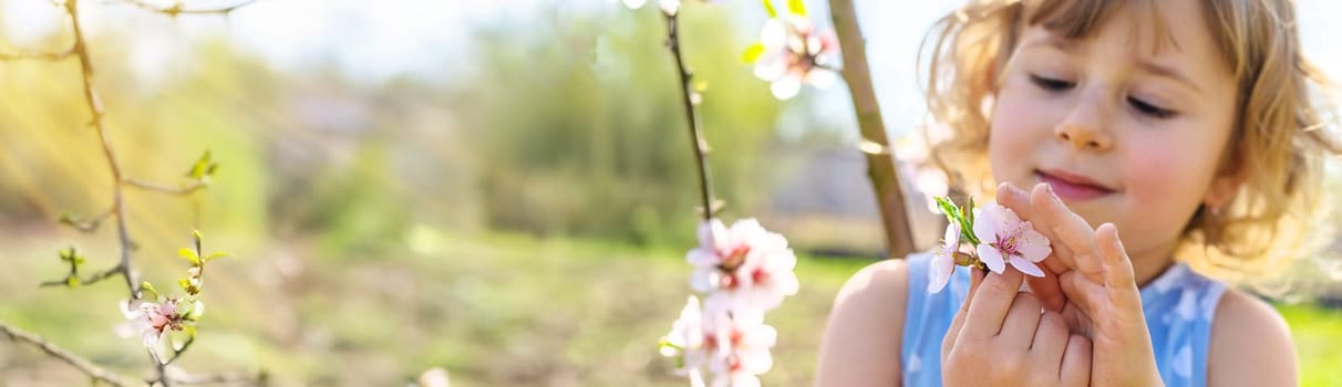 Child in a garden of flowering trees. Selective focus. kid.