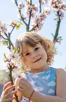 Child in a garden of flowering trees. Selective focus. kid.