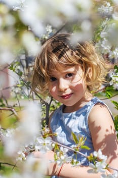 Child in a garden of flowering trees. Selective focus. kid.