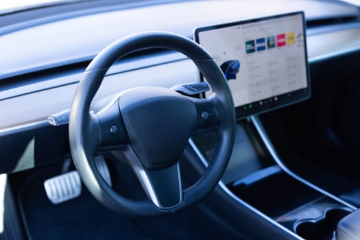 Steering wheel of electric vehicle, interior, cockpit, electric buttons. Autonomous car. Driverless car. Self-driving vehicle. Empty cockpit electric vehicle, Head Up Display and digital speedometer.